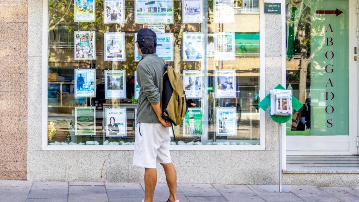 Un joven observa un cartel de una inmobiliaria en Parla, el municipio donde más ha crecido el precio de alquiler de la Comunidad de Madrid.