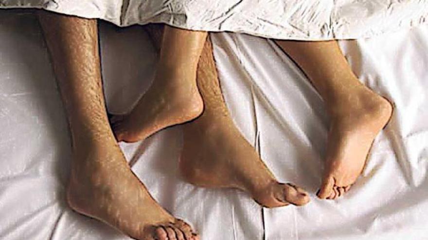 Los pies de una pareja asoman entre unas sábanas.   // FdV