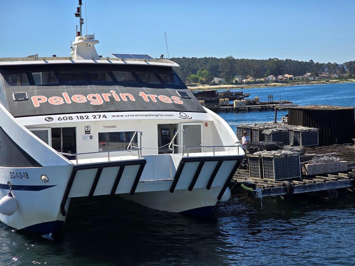 Uno de los catamaranes abarloado a una de las bateas en las que se explica cómo se cultivan mejillón, ostra y vieira.