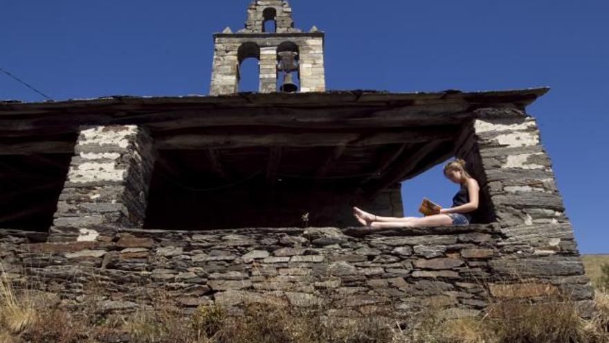 Elisa Pastur Tortosa, tataranieta de Leopoldo Alas, «Clarín», lee un libro ante la iglesia de Labiarón (San Martín de Oscos). | luisma murias