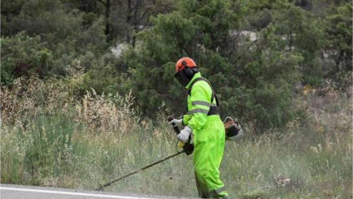 Un operario realizando trabajos de desbroce en una cuneta