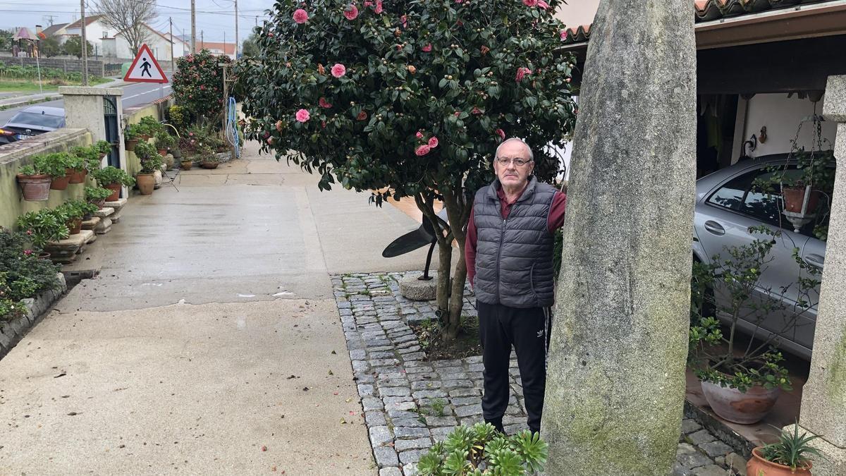 Miguel Brión posa junto al menhir que encontró en 1989 en su finca de Bretal, en Ribeira, y que se puede visitar ante su vivienda