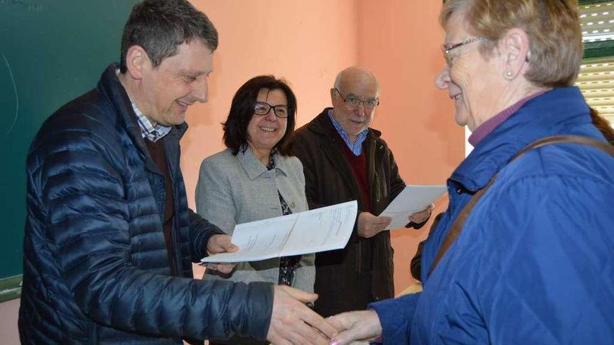 El alcalde de Tineo, José Ramón Feito, entrega la documentación a una vecina, en presencia de María Jesús Álvarez y José Antonio Ferrera, director general de Montes.