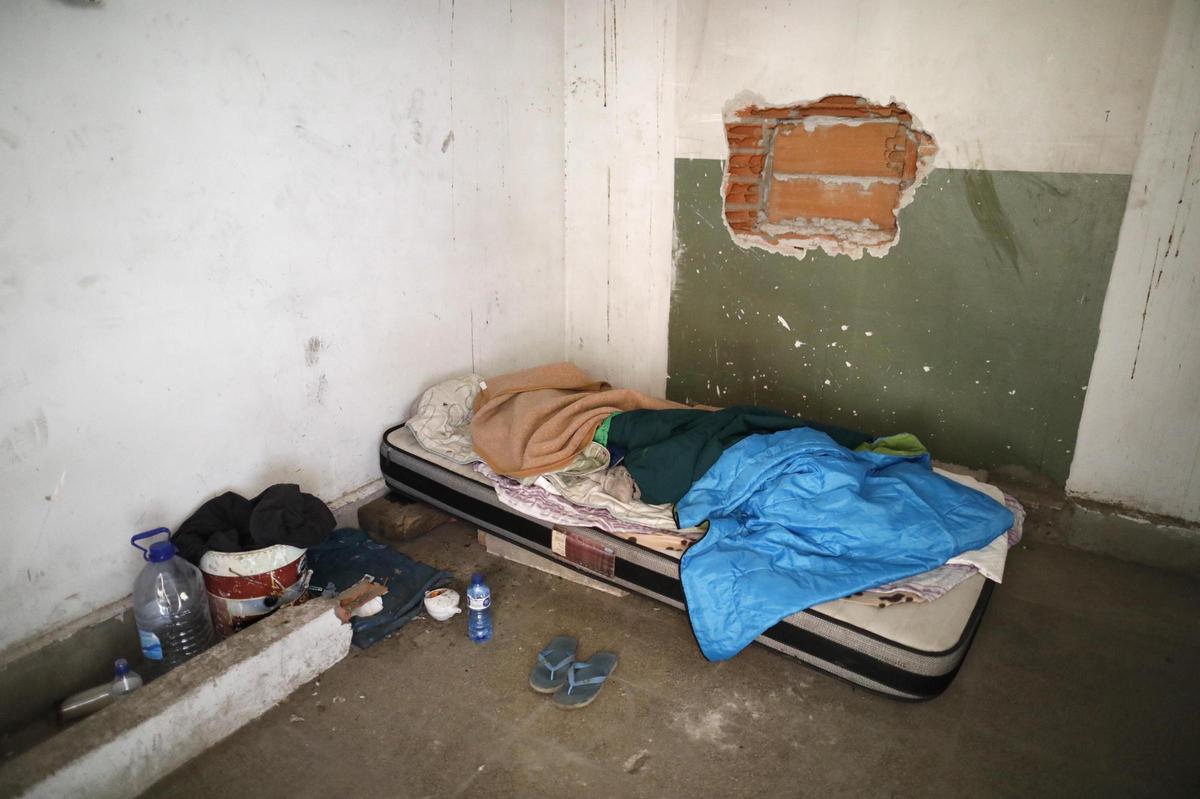 Un llit on dorm una persona sense llar en les instal·lacions.