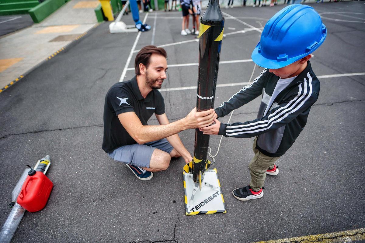 Un niño ayuda a Josuha Barrios a colocar el 'cohete' en la plataforma de despegue.