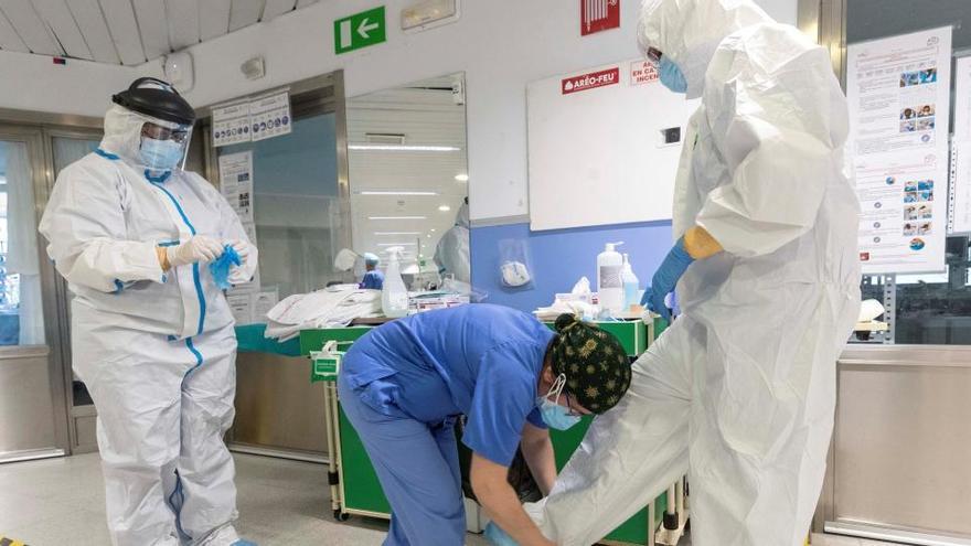 Sanitarios se protegen antes de entrar en un box para atender a un paciente con coronavirus.