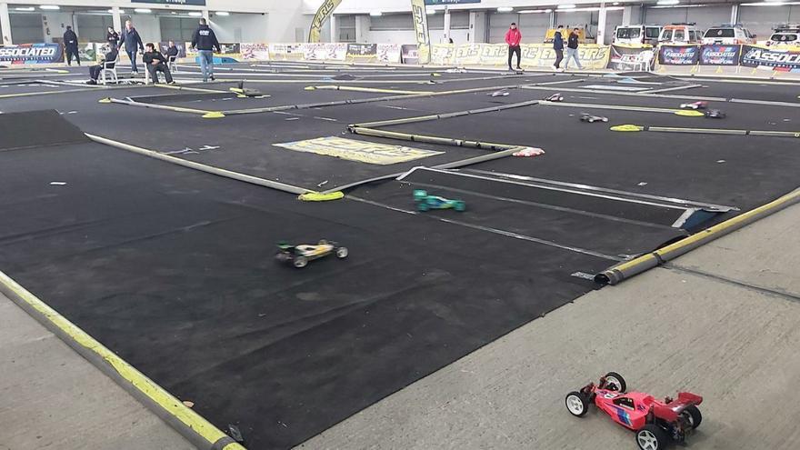 Sobre estas líneas, varios participantes arreglan sus vehículos. Arriba, el circuito instalado en el recinto ferial de Nuevo Santullano. | LNE