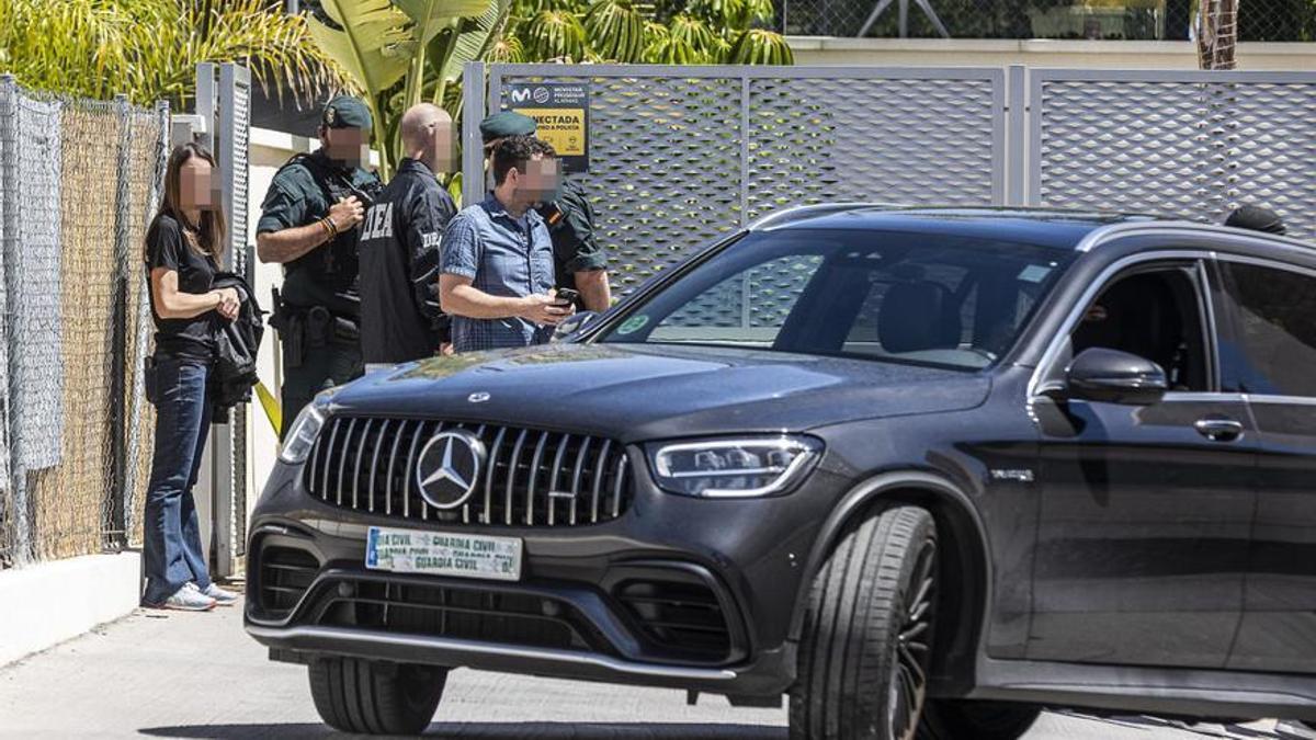 Varios agentes en la puerta del chalet mientras sacan un coche incautado  ALEX DOMÍNGUEZ