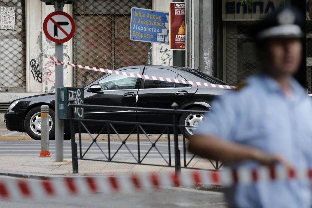 La Policía rodea el coche de Lucas Papademos tras la explosión del artefacto en el interior de su coche.