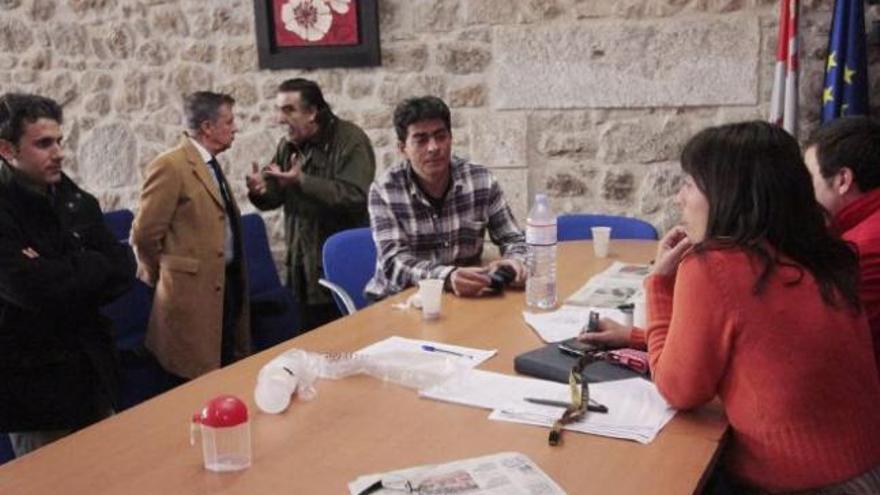 Julio Vaquero explica a Miguel Ángel Mateos la situación mientras otros ediles permanecen sentados en la mesa de plenos.