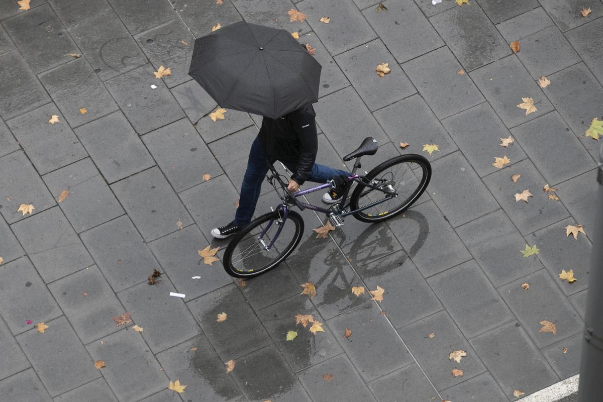 Un hombre lleva una bicicleta.