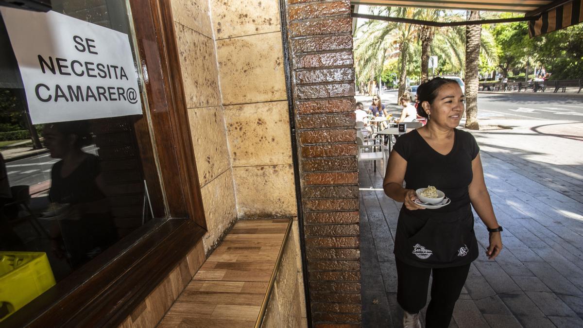 Una camarera atiende una terraza en Alicante en un establecimiento que necesita personal.