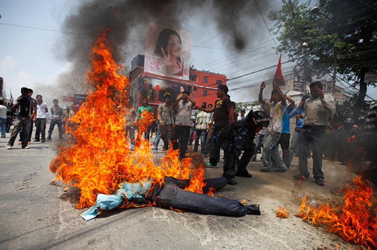 Un agent de la policia de Kàtmandu retira un ninot que representa el primer ministre, Baburam Bhattarai, durant una protesta per exigir la dimissió immediata del mandatari.