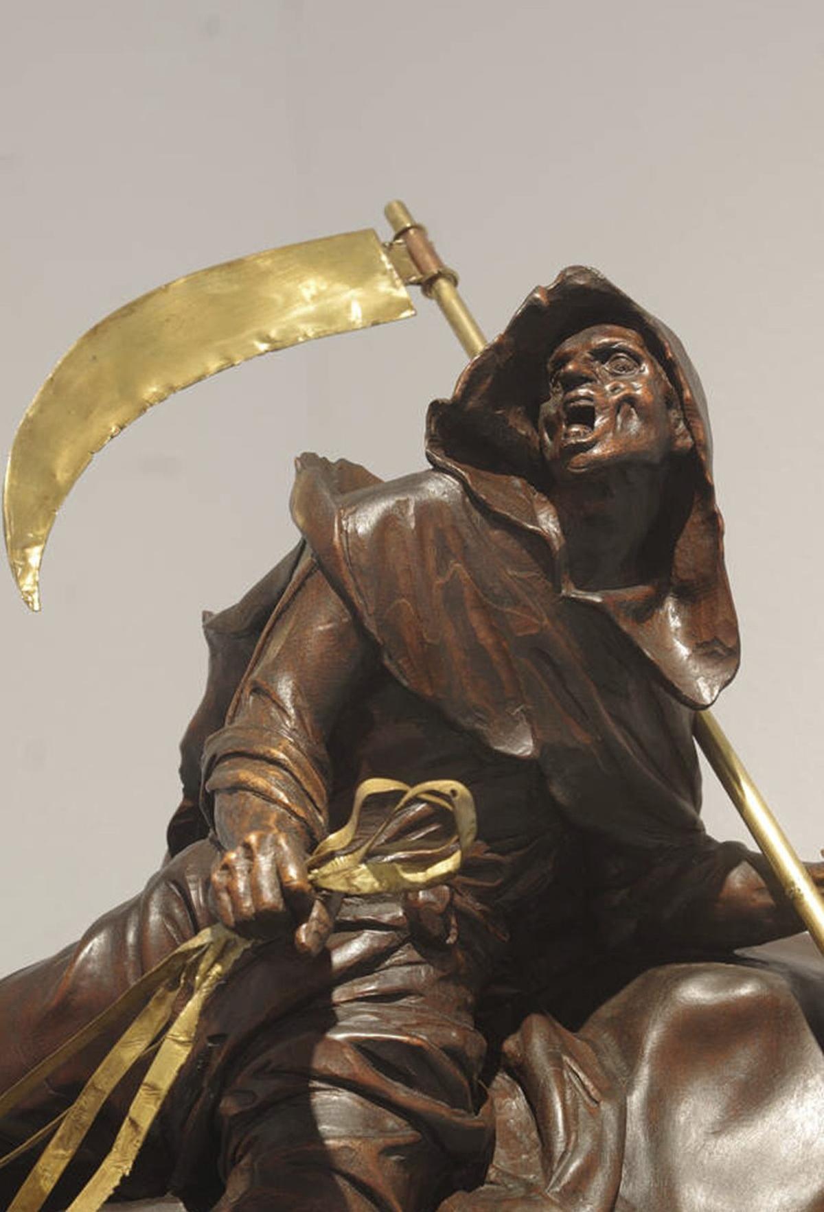 Este es uno de los cuatro Jinetes del Apocalipsis que decoran el trono del Cristo de la Redención, de la Archicofradía de los Dolores de San Juan. En concreto este es La Muerte, obra de José María Ruiz Montes. El Hambre, la Guerra y la Peste son sus compañeros de viaje en los puntos cardinales de este trono.
