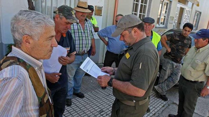 El agente territorial de Deza-Tabeirós, ayer, revisando la documentación de los cazadores.//Bernabé /Cris M.V.