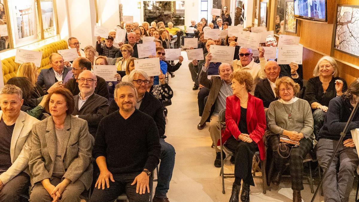 Los socios y socias de Ebusus desde hace más de 35 años alzan el diploma que se les ha entregado.