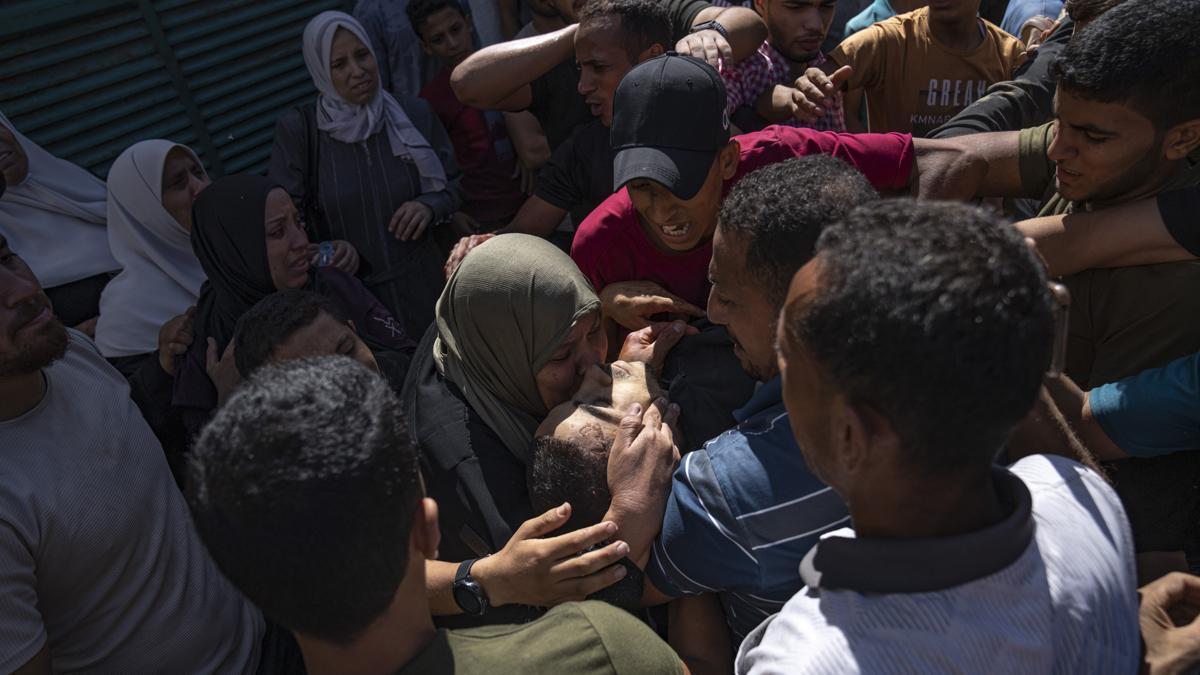 Ciudadanos palestinos llevan el cuerpo de un hombre que ha resultado muerto durante los ataques con las fuerzas israelís en la ciudad de Gaza.