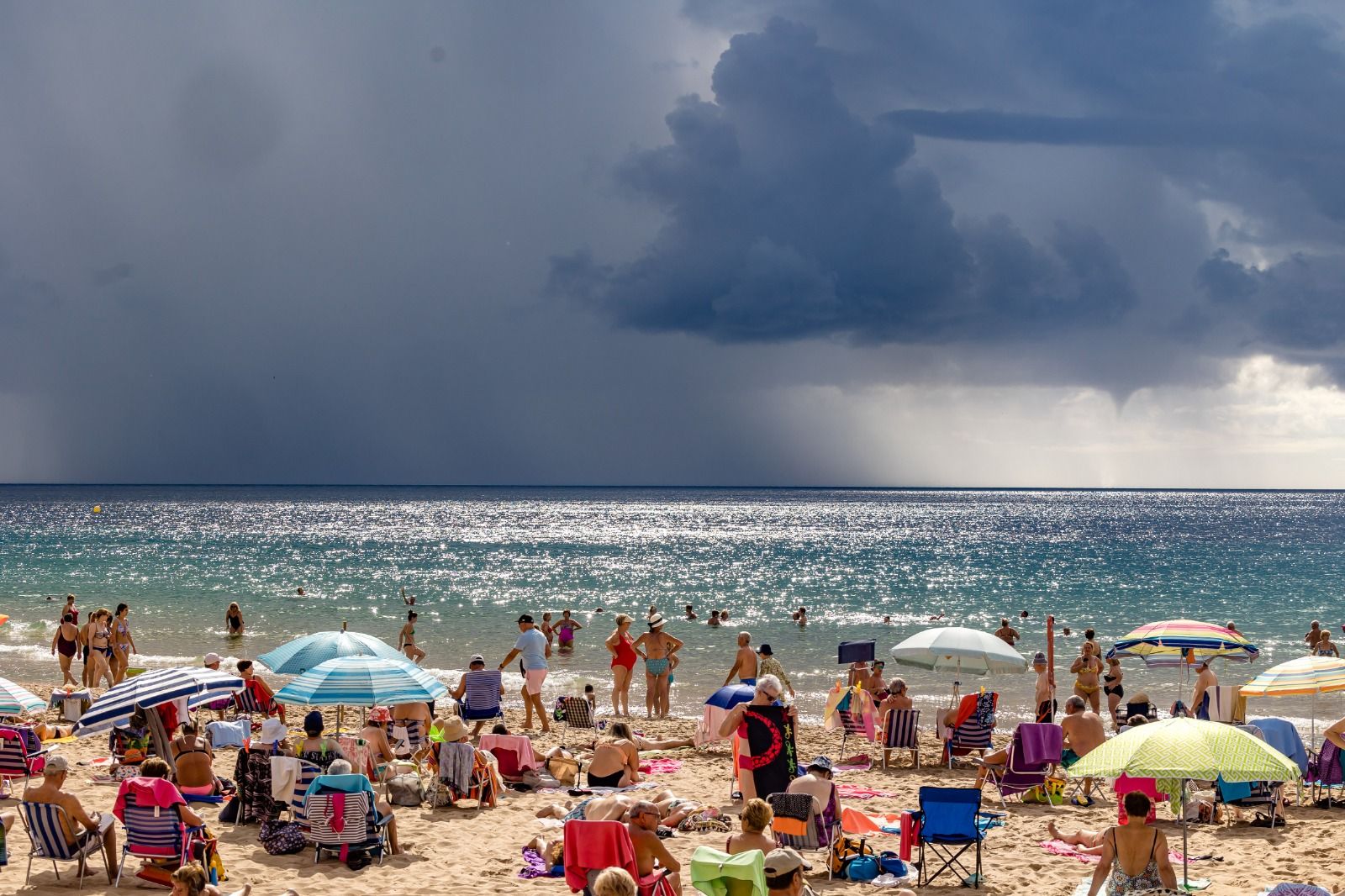 Los bañistas permanecen en las playas de Benidorm pese a la amenaza de lluvias