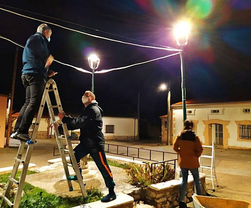 Miembros de la asociación de Tardobispo instalan la iluminación. | Cedida