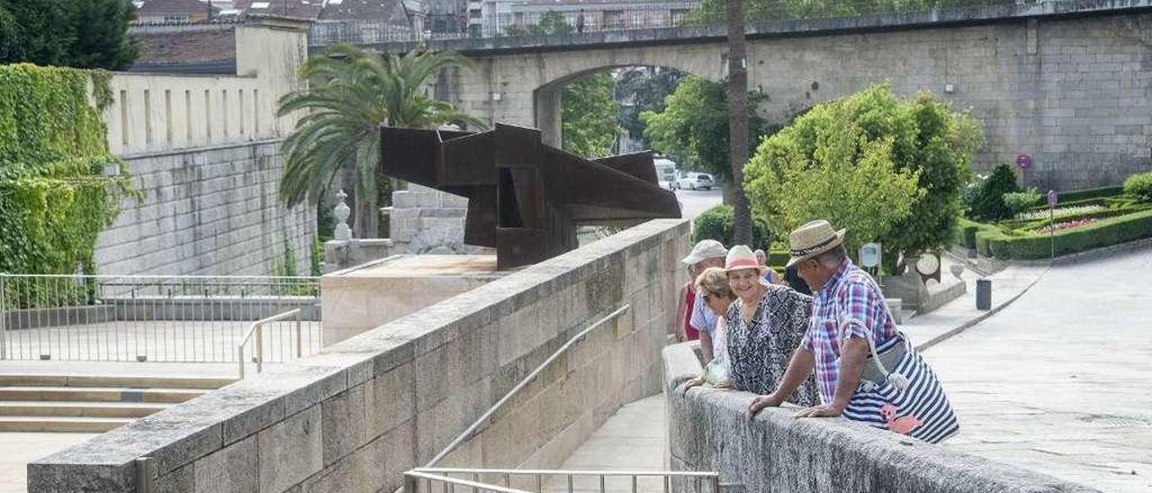 Un grupo de turistas visitan As Burgas y la piscina termal, todavía cerrada por mantenimiento. // Carlos Peteiro