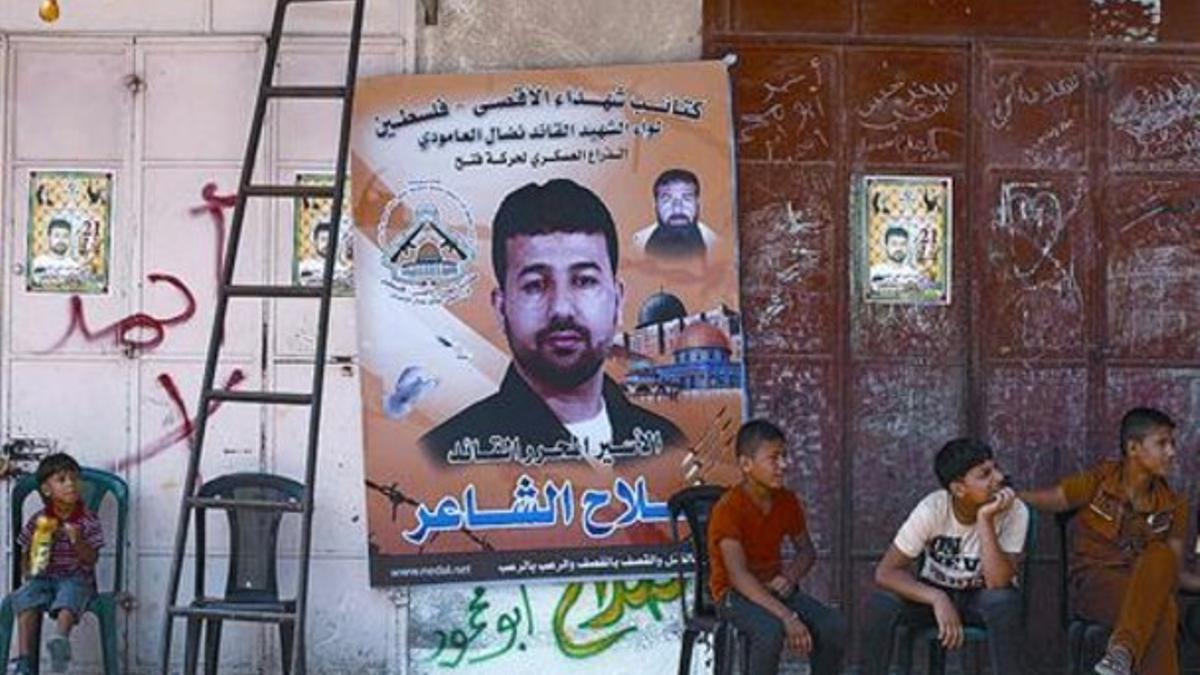 Unos palestinos, en casa de Salah al Shaer, uno de los presos que iba a ser liberado, con su foto en el póster.