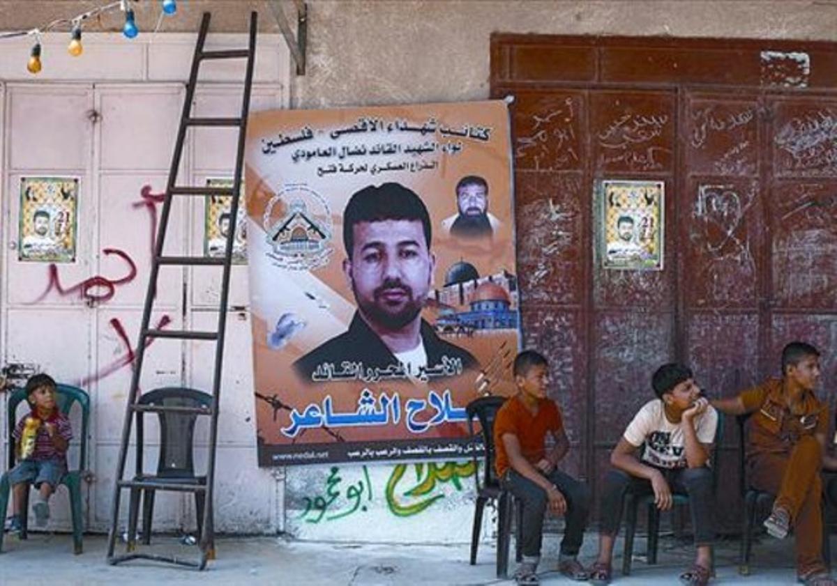 Uns palestins, a casa de Salah al-Xaer, un dels presos que anava a ser alliberat, amb la seva foto al pòster.