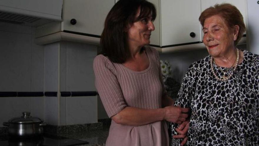 Lita Rivero, con su madre, Consuelo Fernández, ayer, en la cocina de su casa de Luanco.