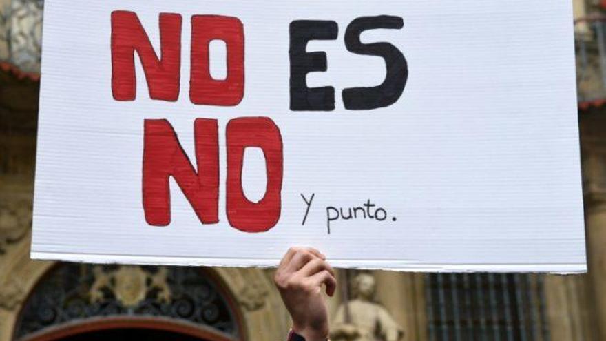 Una persona porta una pancarta en una manifestación.