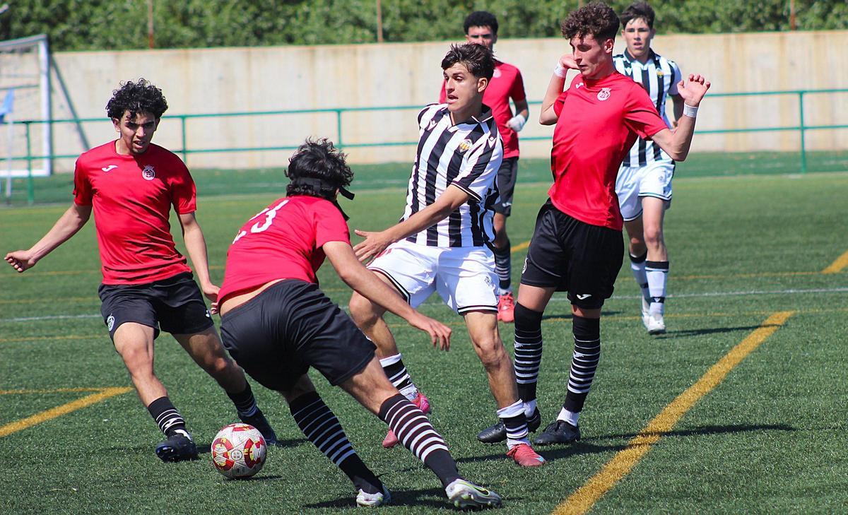El albinegro Mario Albert, rodeado de futbolistas del Conquense.