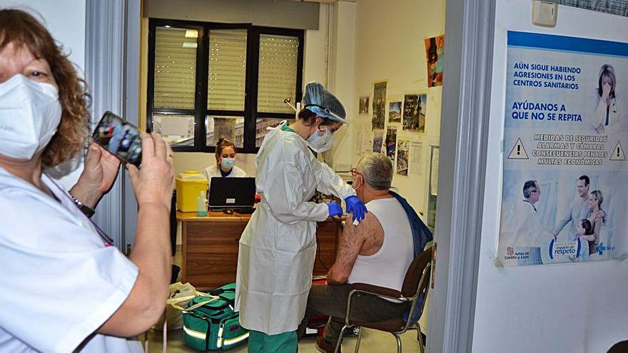 Una trabajadora fotografía a un compañero que se vacuna en Lubián. | A. S.