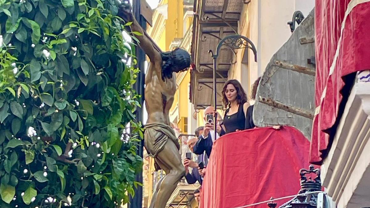 Díaz Ayuso contempla el paso del Cristo de la Fundación de Los Negritos por la Cuesta del Bacalao.