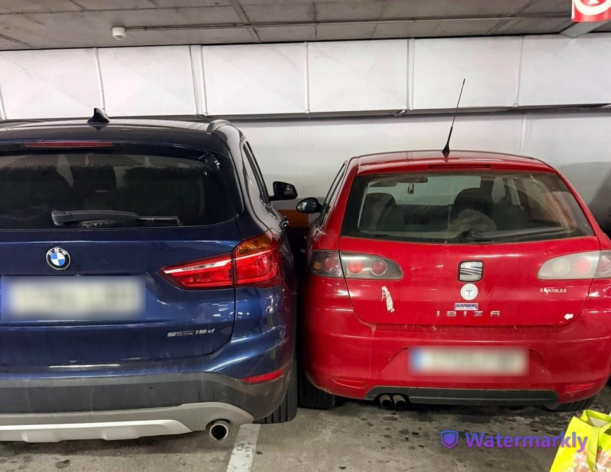 Los dos vehículos: el rojo, aparcado inicialmente, y el BMW que estacionó después pegado.