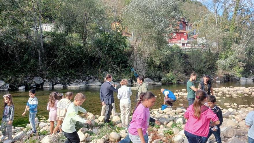 Un momento de la suelta de las truchas en el río.