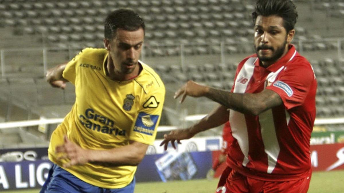 Hernán Santana (izquierda) pugna con el defensa francés Benoît Trémoulinas durante el Las Palmas - Sevilla de la Liga BBVA 2015/16