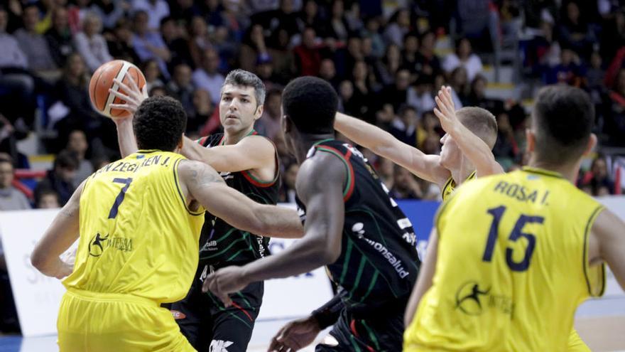 Bivià con el balón entre varios jugadores del Oviedo Baloncesto.