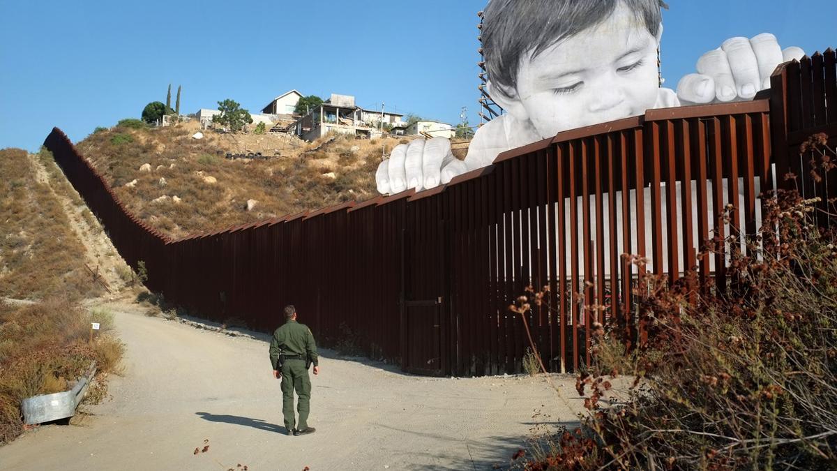 ARTISTA FRANCÉS LEVANTA A UN NIÑO GIGANTE ENTRE FRONTERA DE EE.UU. Y MÉXICO