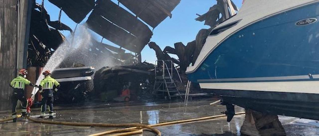 Dos bomberos realizaban ayer labores de refresco en la nave calcinada por las llamas.