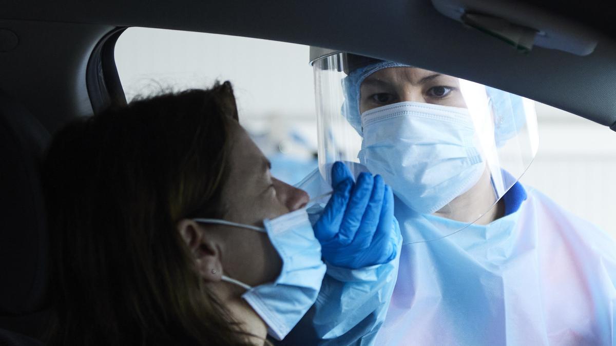 Archivo - Una sanitaria le realiza la prueba PCR a una mujer en su coche.