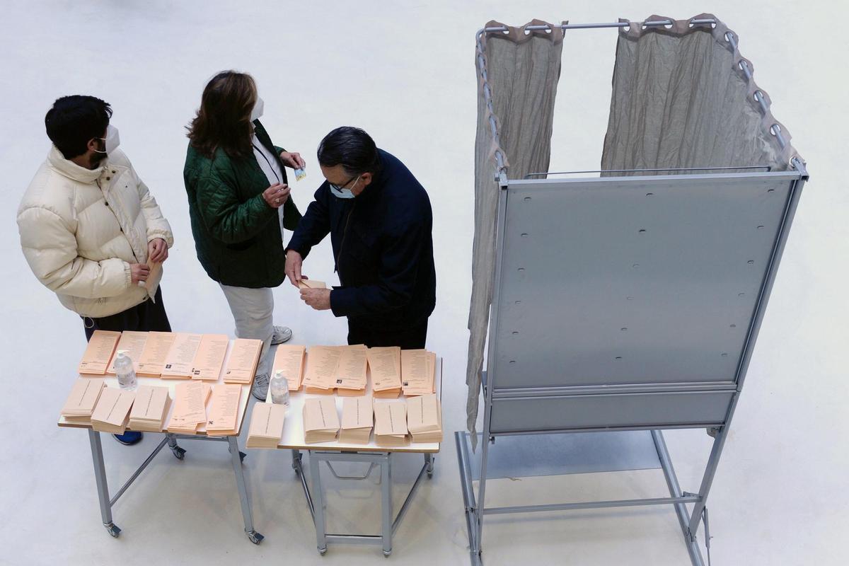 Tres personas preparan su papeleta de votación en un colegio electoral de Valladolid. EFE/ Nacho Gallego