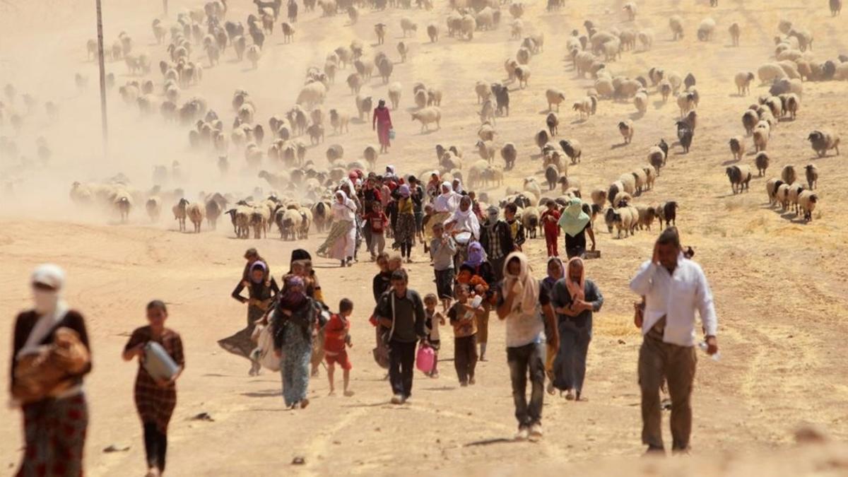 Desplazados yazidís huyen hacia la frontera siria, en los alrededores del monte Sinjar, ante el avance de las milicias del EI, el 10 de agosto del 2014.