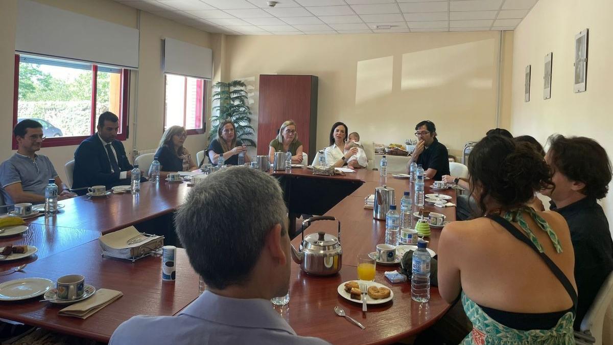 La consejera Sara García Espada, con un bebé en los brazos, junto a las familias de acogida durante un desayuno en Badajoz.