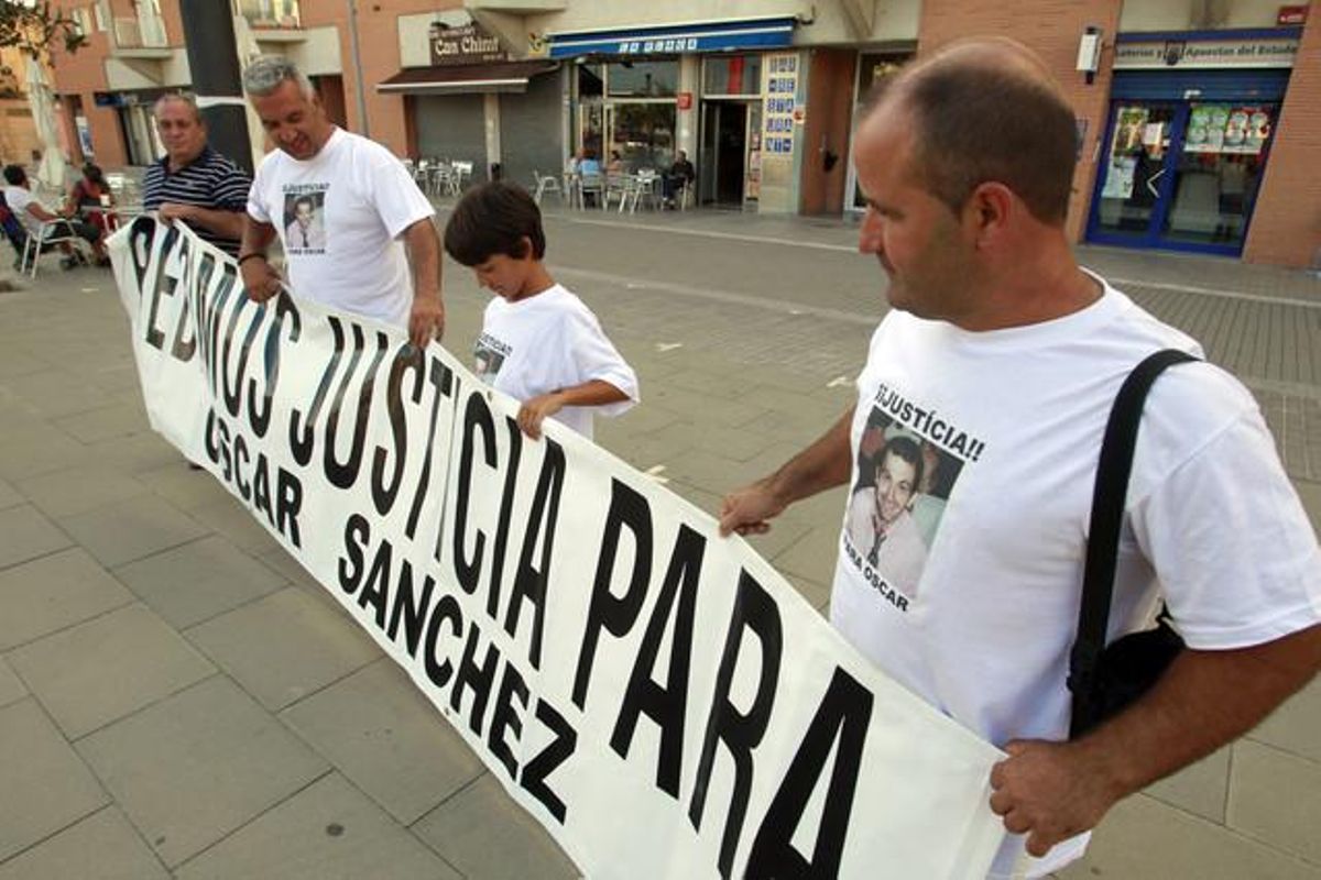 Familiars i amics del rentacotxes sostenen una pancarta de suport al reclús, a la plaça de les Mallorquines de Montgat.