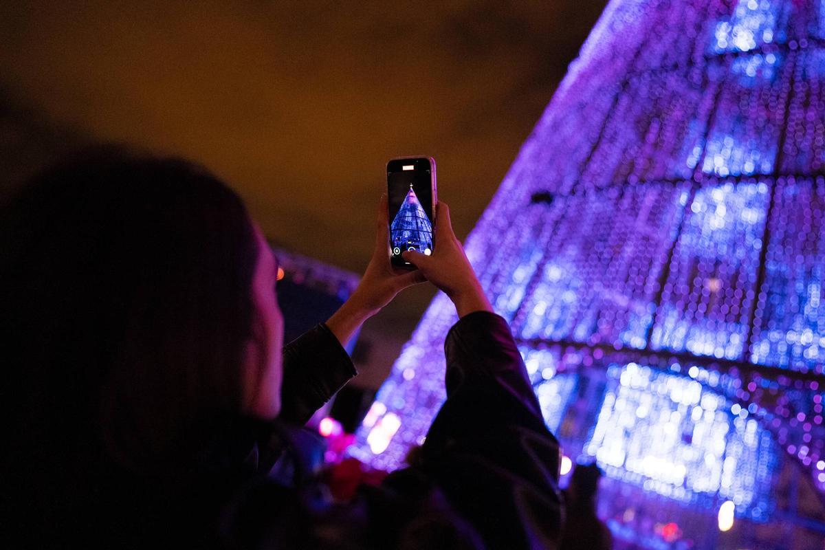 El árbol de Navidad de Badalona, visto a través de la pantalla de una asistente a la inauguración