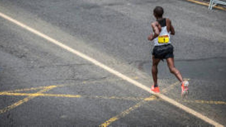 Un atleta de élite sigue la línea oro en el asfalto de Valencia.