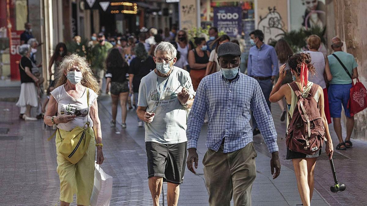 Varias personas mayores dando un paseo por el centro de Palma.