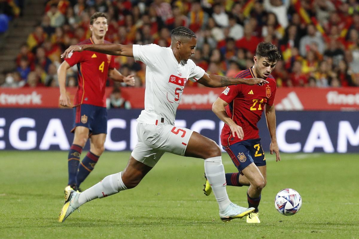 ZARAGOZA, 24/09/2022.- El jugador español Pedri González (d) disputa un balón al suizo Manuel Akanji durante el partido de la Liga de Naciones que España y Suiza disputan este sábado en el estadio de La Romareda, en Zaragoza. EFE/Toni Galán