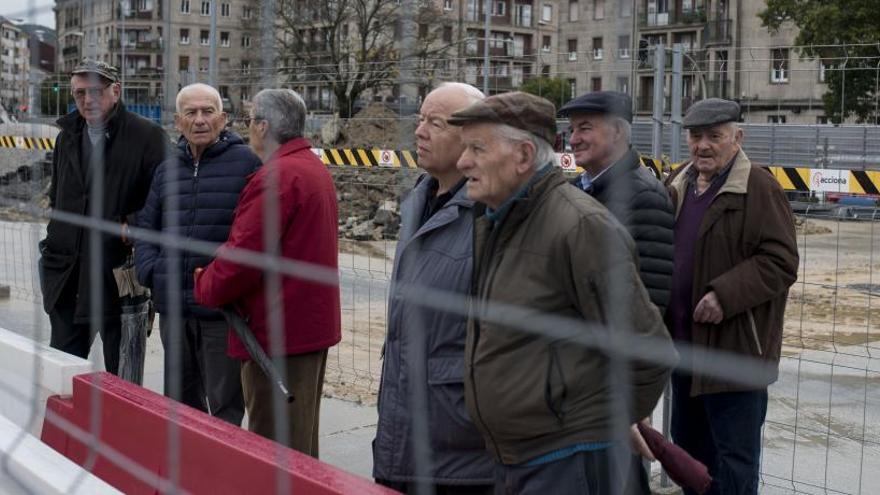 Un grupo de jubilados observa una obra.