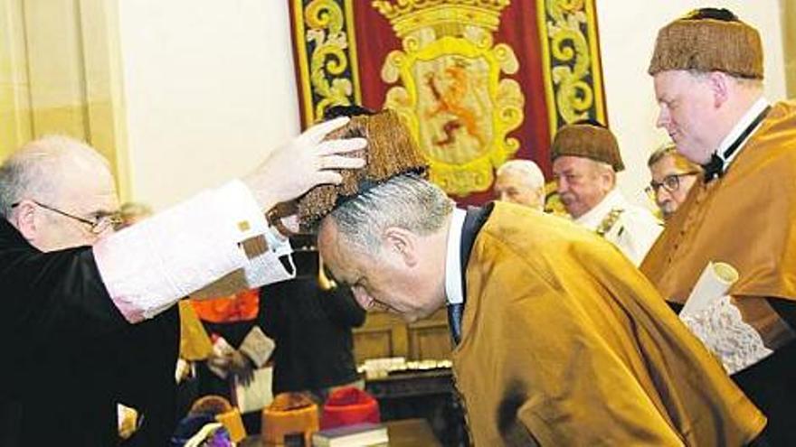 El rector coloca el birrete de doctor a Juan Carlos Torres Inclán. Tras él, Paul Younger y Andrzej Karbownik, junto a sus padrinos.