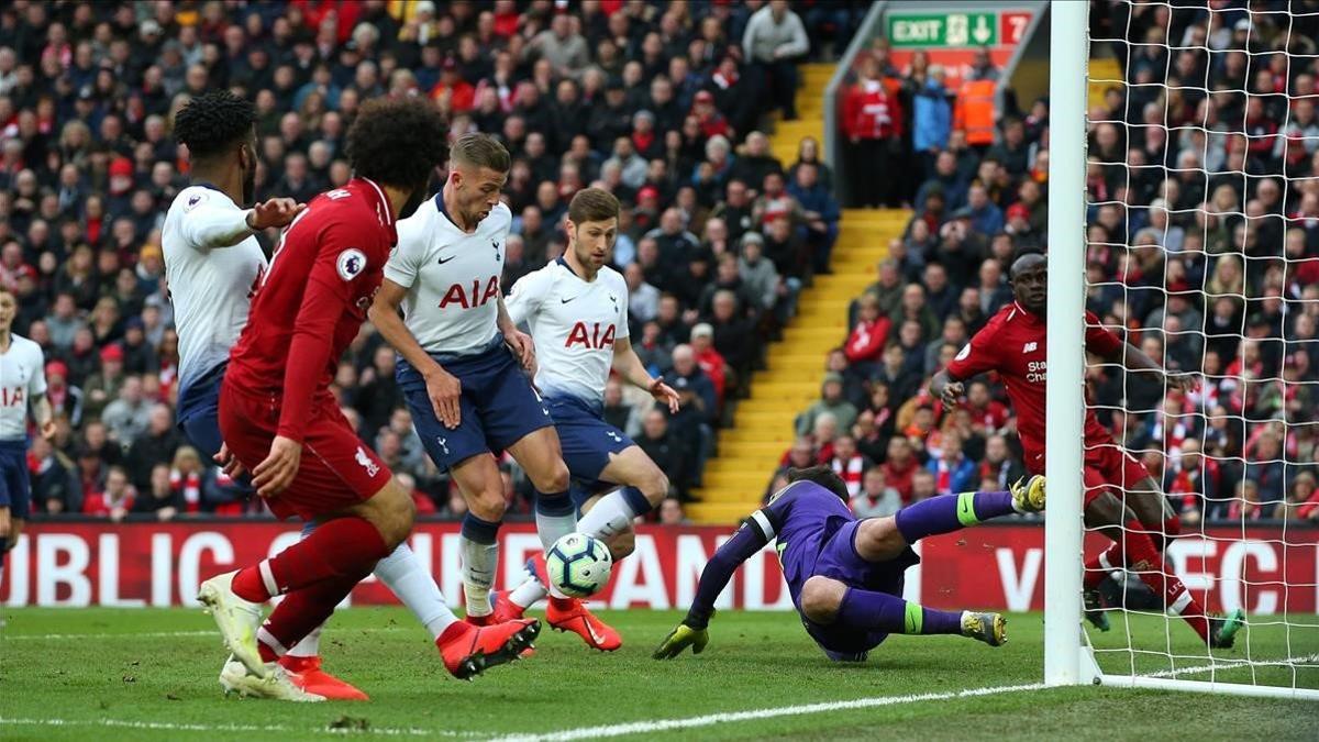 Salah observa como su cabezazo es mal despejado por Lloris y toca en Alderweireld.