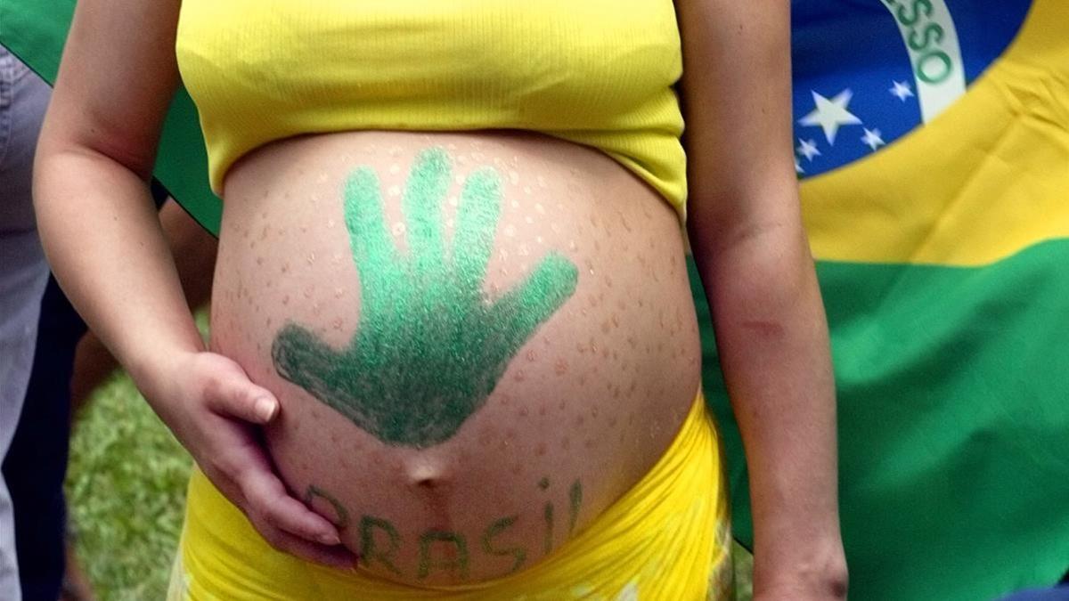A pregnant Brazilian soccer fan watches the World Cup final match  on a large screen television in central Madrid June 30  2002  Brazil won a record fifth World Cup on Sunday when Ronaldo erased the memory of his 1998 final nightmare by scoring both goals in a 2-0 victory over Germany      REUTERS Andrea Comas